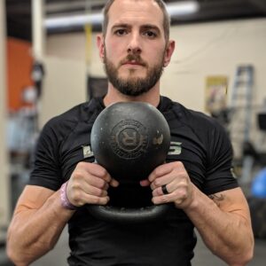 Daniel holding a kettlebell close to chest